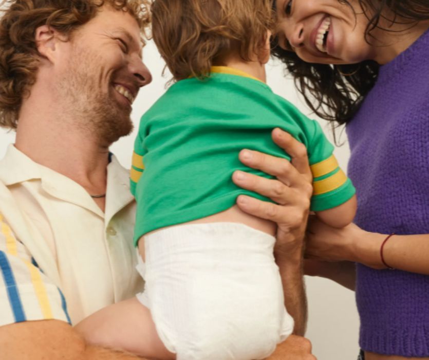 mamãe e papai segurando bebê usando fraldas de círculo